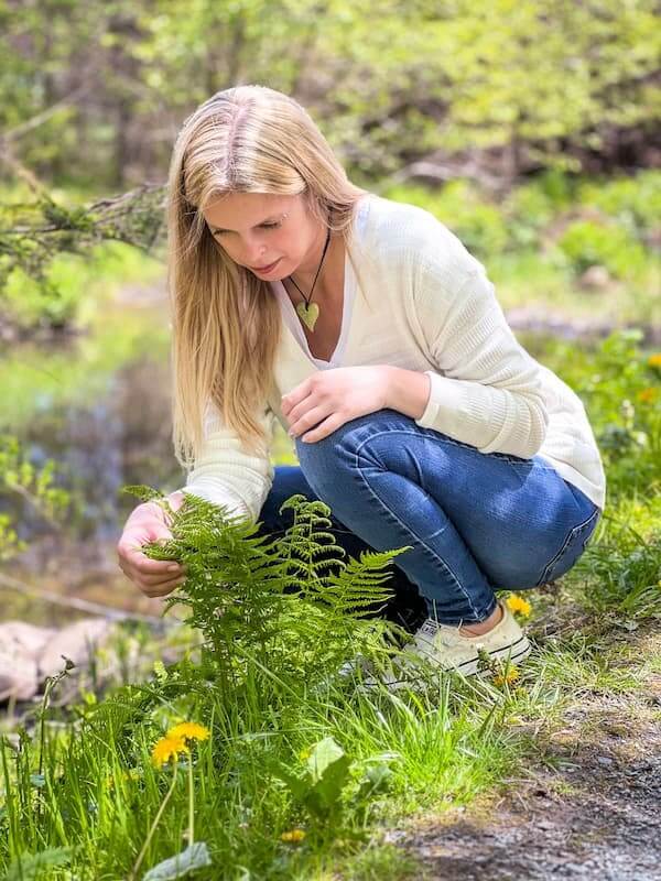 About Jill MacKay - Energy Recovery Specialist for Women, photo in nature looking at vibrant green fern