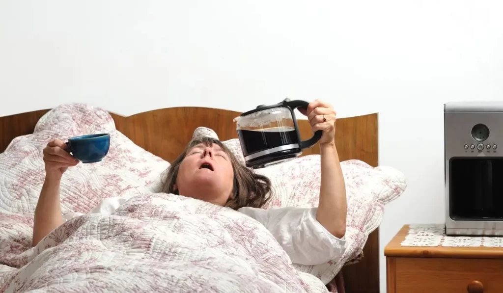 Tired woman holding a coffee pot and mug—feature image for 7 signs your nervous system is in survival mode.